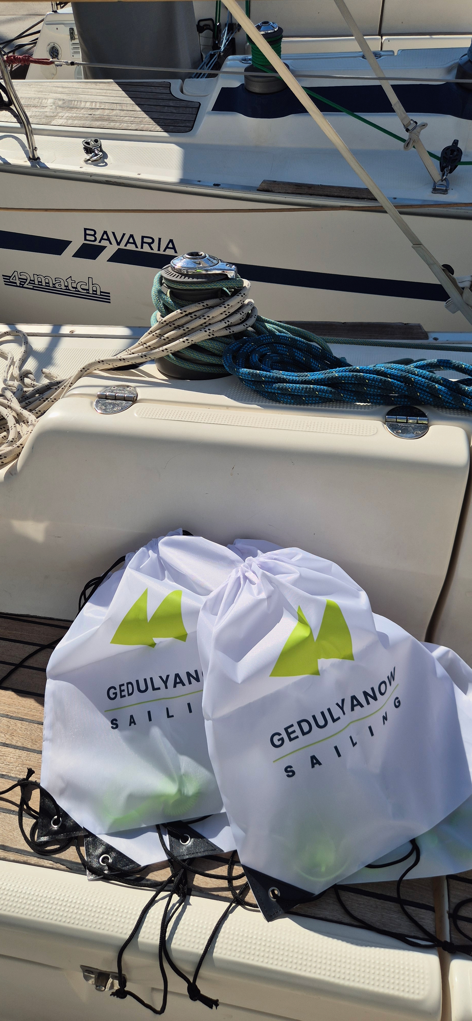 Белые фирменные мешки Gedulyanow Sailing на палубе Bavaria